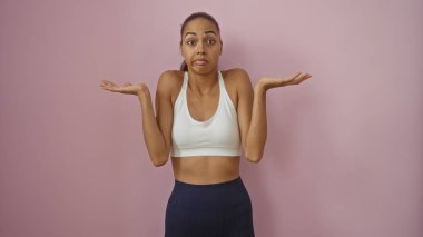 Kafası karışmış genç bir kadın pembe bir arka plan duvarında izole edilmiş.