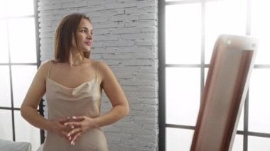 Parlak, şık bir yatak odasında, beyaz tuğlalı duvarları olan bir kadın sabah güneşinde kendini dinlenmiş ve rahatlamış hisseder..