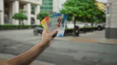 Elinde İsviçre frangı banknotları olan bir adam, şehir içi arkaplan ve açık hava paralarını sergiliyor..