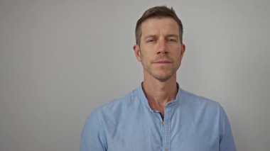 İzole edilmiş beyaz bir arkaplanda gülümseyen genç adam açık mavi bir gömlek giyiyor modern ve profesyonel bir görünüm sergiliyor güven ve olumluluk taşıyor..