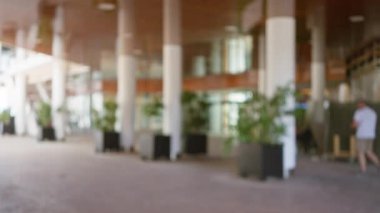 Bitkiler ve arka plan mimarisi ile bulanık, bokeh dış mekan manzarası modern şehir ortamında odakları kesilmiş bireylerin yer aldığı