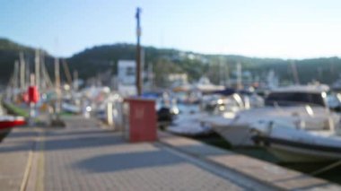 Güneşli bir günde liman atmosferinin huzur ve güzelliğini vurgulayan bulanık tekne ve marina manzarası