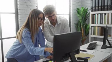 Modern bir ofiste bilgisayar başında işbirliği yapan erkek ve kadın takım çalışmasını ve iş profesyonelliğini kapalı alanlarda sergilediler..