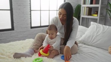 Anne ve kızı rahat bir yatak odasında oyuncaklarla oynuyorlar, evde sevgi ve aile bağlarını paylaşıyorlar, aile birliğini ve sıcaklığı vurguluyorlar..