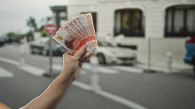 Elele tutuşan Norveçli kronlar açık hava sokak ortamında bir adamı içeren seyahat ya da finans....