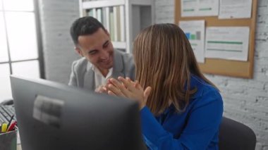 Parlak, modern bir ofiste alkışlayan ve gülümseyen erkek ve kadın neşeli ve işbirlikçi bir çalışma ortamı yaratıyor..