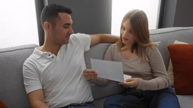 Kanepede oturan çift, birlikte bir mektup okurken ve sıcak bir oturma odasında kucaklaşırken, sevgi ve bağın altını çizerken, neşeli bir anı paylaşıyor..