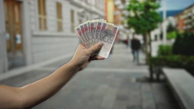 Şehir sokaklarında uzak bir adamla el ele tutuşup Polonya 'da para ve şehir yaşamını gözler önüne seriyor..