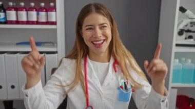 Üniformalı genç beyaz kadın doktor şaşkına döndü ve kliniği işaret ederek şaşkınlıkla gülümsedi.