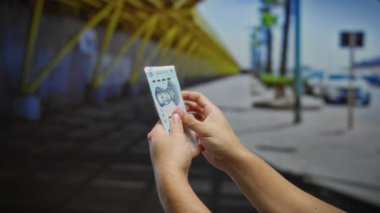 Şehrin dış kesimlerinde Çin Yuan banknotları elinde tutan adam, iş ortamı sağlayan şehir ortamında para etkileşimi sergiliyor..