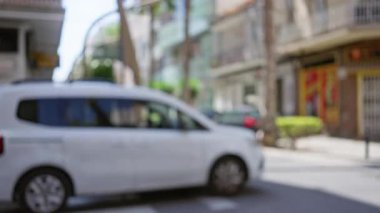 Odaklanamayan binalar, bokeh etkisi ve sokakta beyaz bir araba olan bir şehirde bulanık bir arkaplan.