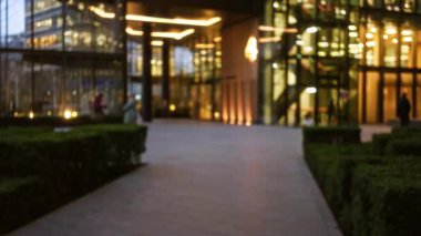 Londra 'daki bulanık şehir gece sokak sahnesi. Dağılmış ışıklar, modern mimari ve yayalar Birleşik Krallık' ta kış akşamı atmosferini yakalıyor..