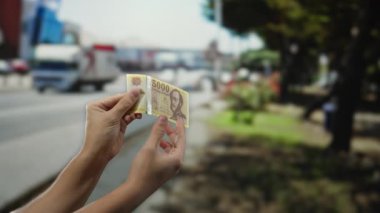 Meşgul bir şehir caddesinde Macar banknotları tutan adam, şehir yaşamını ve dışarıdaki ekonomik kavramları Hungary 'de gösteriyor..