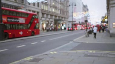 Kış boyunca Londra caddesinde Bokeh Noel ışıkları İngiltere 'deki şenlik atmosferini artırırken ikonik kırmızı otobüsün bulanık görüntüsü..