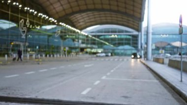 Havaalanı terminalinde bavullu bir adamın görüntüsü bulanık. Yoğun bir açık hava ortamında seyahat kavramını vurguluyor..