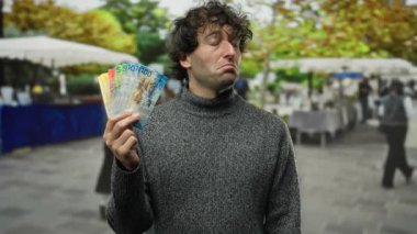 İsviçre frangı banknotları tutan bir adam şehir merkezinde bir sokakta, İsviçre ekonomisi ve kültürüyle bağlantılı bir finans ve seyahat duygusu taşıyor..
