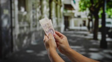 Şehir caddesinde tek başına dolar sayan bir adam, Türk parasıyla şehir dışı ortamında yatırım ve ticareti ön plana çıkarıyor..