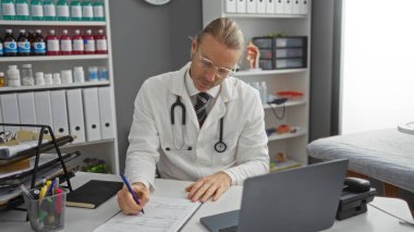 Doktor, tıbbi malzeme ve dosyalarla çevrili bir klinik masasına steteskopla profesyonel bir sağlık ortamını gösteren notlar yazıyor..