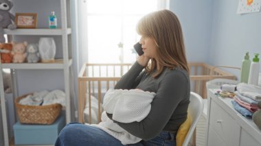 Kadın telefonda konuşuyor bebek odasında, beşik ve oyuncaklarla, modern anneliği vurguluyor, ev ortamında rahatlık, yumuşak ışıklandırma odayı vurguluyor..