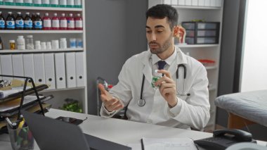 Klinikteki genç bir adam bir hastane odasında tıbbi ekipman ve profesyonel ortam sunan, sağlık hizmetleri iletişimini gösteren bir video danışma hizmeti sunar..