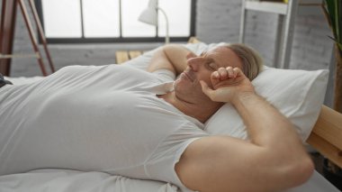 Olgun bir adam, rahat bir duruşu olan, rahat ve sükuneti yansıtan, rahat bir yatak odasında, kapalı bir odada huzur içinde uyuyor..