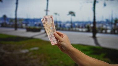 Adam açık havada bir sokak arkaplanına notlar tutuyor, finans ve şehir yaşam tarzının bir karışımını yakalıyor..