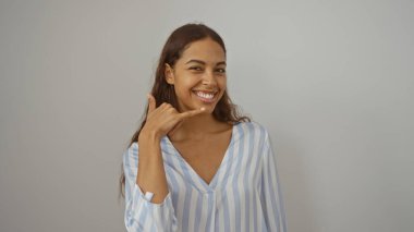 Duvarın arkasında el hareketleriyle gülümseyen bir kadın. Genç Afrikalı Amerikalı esmer, Latin asıllı, güzel bir Latin.