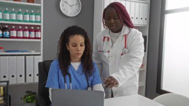 Tıbbi malzemeler ve dizüstü bilgisayarla bir hastane odasında işbirliği yapan kadın doktorlar sağlık hizmetlerinde takım çalışması sergiliyorlar..