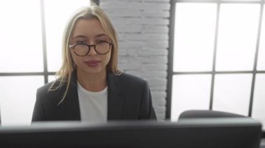 Kadınlar ofis masasında iş konuşuyorlar, bilgisayarlar parlak, modern kapalı bir çalışma alanında görünür, profesyonel bir ortamda işbirliği sergiliyorlar..