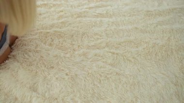 Yatak odasında rahat bir şekilde uzanan, mavi iç çamaşırı giyen ve evinde mutlu mesut gülümseyen bir kadın..