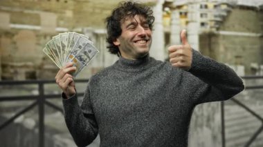 Amerikan dolarlarını elinde tutan İspanyol adam Roma harabeleri arasında çeşitli jestler yapıyor. Açık hava tarihi ortamında karşıt onay ve hoşnutsuzluk duyguları sergiliyor..