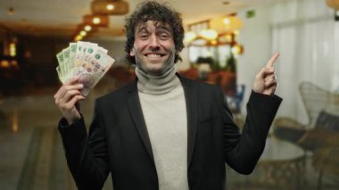 İçerde gülümseyen İspanyol bir adam rahat bir kahve dükkanında Arjantin pezosu tutuyor, zenginliği ve mutluluğu canlı bir yaşam tarzında somutlaştırıyor..