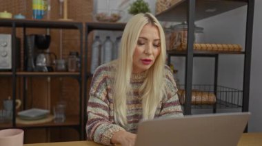 Evinden çalışan bir kadın rahat bir oturma odasında endişe dolu bir ifadeyle çalışıyor.