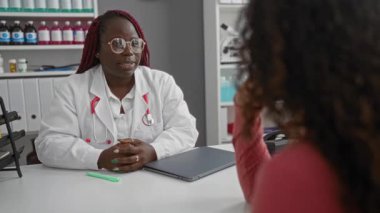 Steteskoplu kadın doktor hastane ofisinde hastayla görüşüyor ve muayene sırasında sağlık sorunlarını tartışıyor..