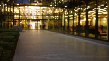 Londra 'daki aydınlık şehir caddesinin bulanık görüntüsü. Sonbaharda kentsel atmosferi gösteren cam binalara yansıyan bokeh ışıkları var..