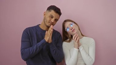 Çift pembe bir duvarın önünde birlikte dua ederek huzur ve maneviyat ifadeleri sergileyen bir erkek ve kadınla huzurlu ve samimi bir atmosfer yaratıyor..