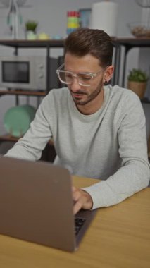 Modern bir ofiste dizüstü bilgisayarda çalışan İspanyol bir adam elleri başının üstünde rahatlıyor, sakin ve odaklanmış bir atmosfer sergiliyor..