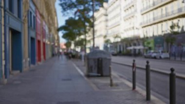 Marsilya 'daki bulanık sokak manzarası renkli binalar, dağılmış yayalar ve yumuşak odak içindeki kentsel manzara rüya gibi Avrupa atmosferini artırıyor.