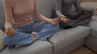 Oturma odasında birlikte meditasyon yapan kadınlar rahatlama, huzur, yoga, farkındalık ve huzur dolu bir atmosferle evlerinde huzur ve ahenk sağlıyorlar..