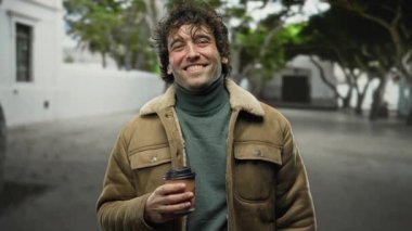 Genç bir adam kışın şehir sokaklarında elinde kahve fincanı tutarak gülümsüyor. Ağaçlı bulanık bir şehir geçmişine karşı mutluluk ve samimiyet sergiliyor..