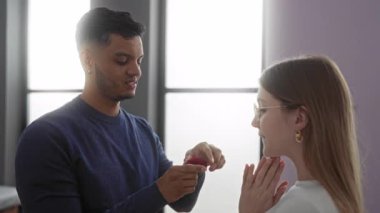 Erkek, evde bir kadına aşk ve şaşkınlık ifadesiyle romantik ve samimi bir ortam yaratarak evlenme teklif ediyor..