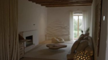 İçinde şömine olan lüks bir Akdeniz tarzı oturma odasının bulanık görüntüsü ve çözünmüş elementlerin bulunduğu modern dekorasyon hoş ve zarif bir ortam yaratıyor..