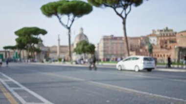 Roma forumunun tarihi kalıntılarını ikonik ağaçlar ve mimariyle araştıran bulanık insanlar, antik şehir hakkında rüya gibi ve odak dışı bir izlenim yarattılar..