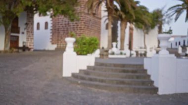 Lanzarote 'daki dış mekan sahnesi, basamakları, ağaçları, beyaz yapıları olan İspanya ve bulanık bir arka plan.