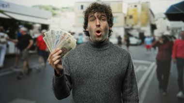 Şehir sokaklarında İspanyol bir adam Czech Koruna banknotları tutuyor. Bulanık yayalar arasında şaşırmış görünüyor. Beklenmedik finansal kazanç ima ediyor..