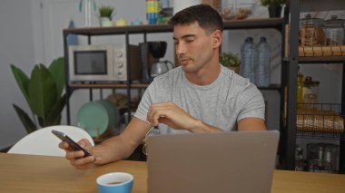 Modern ofis ortamında bilgisayarlı akıllı telefon kullanan ve ön planda kahve kullanan adam verimli bir çalışma ortamı olduğunu gösteriyor..