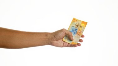 Beyaz bir arkaplana karşı 10 İsviçre frankı banknot tutmak, İsviçre 'den izole ve net bir şekilde para birimini vurguluyor