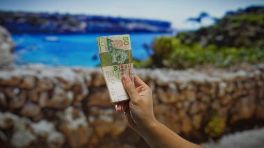 Sahilde el ele tutuşan Hong Kong dolarları, canlı bir sahil kasabasında yaz tatili boyunca deniz kenarı yatırımlarının ve döviz kurlarının altını çiziyor..