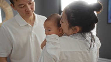 Anne ve babanın modern oturma odasında sevgiyle izlediği aile sahnesi..