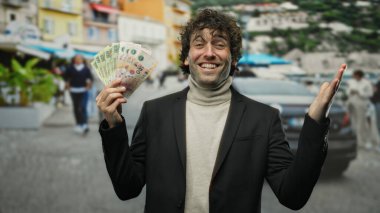 Gülümseyen adam Arjantin pesolarını şehir sokaklarında tutuyor neşeli açık hava anlarını renkli arka planlarla yakalıyor finansal başarıyı gösteriyor.